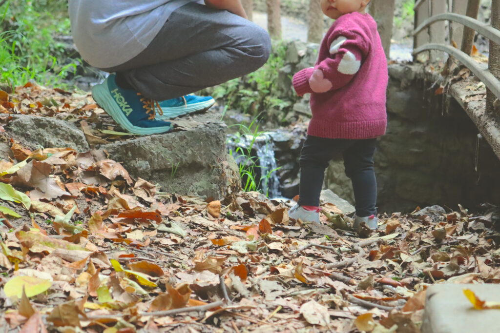 Toddler spending time outdoors in nature with her father.